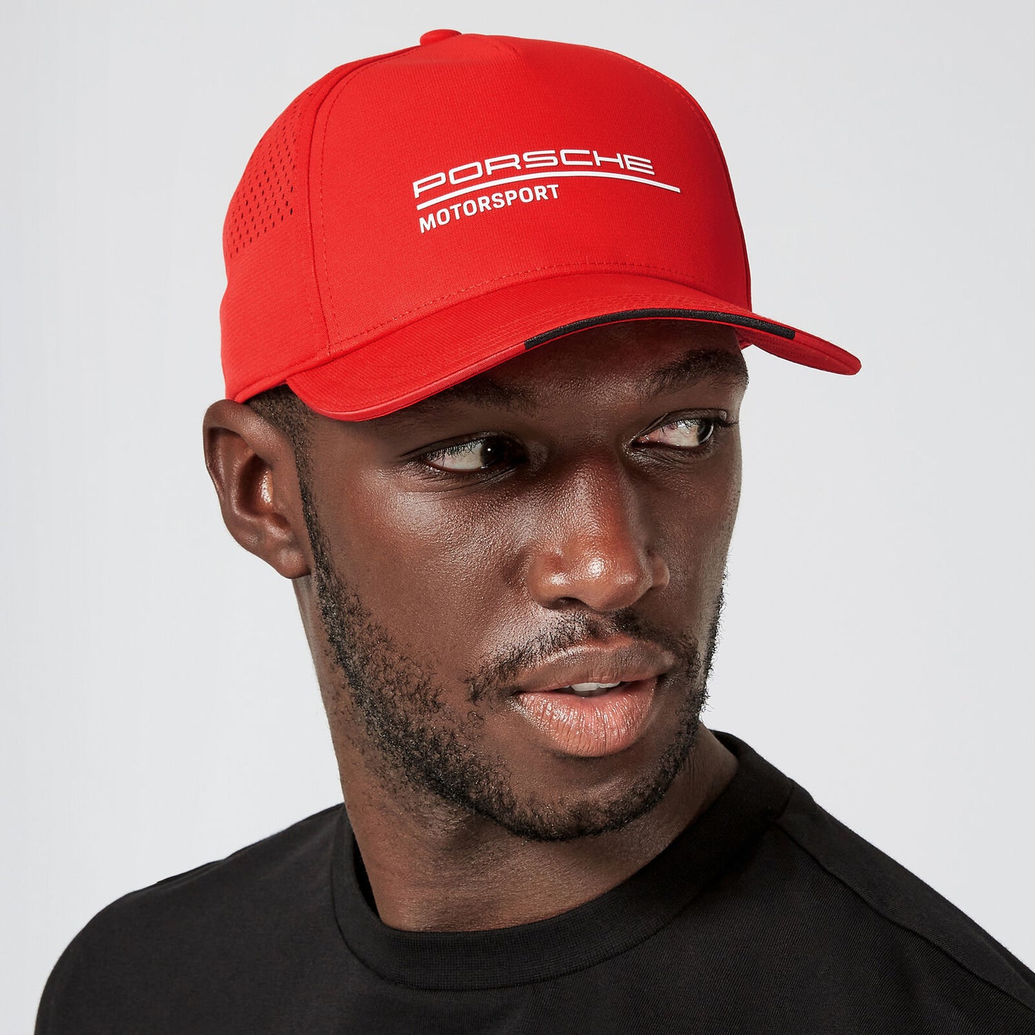man wearing red Porsche baseball cap